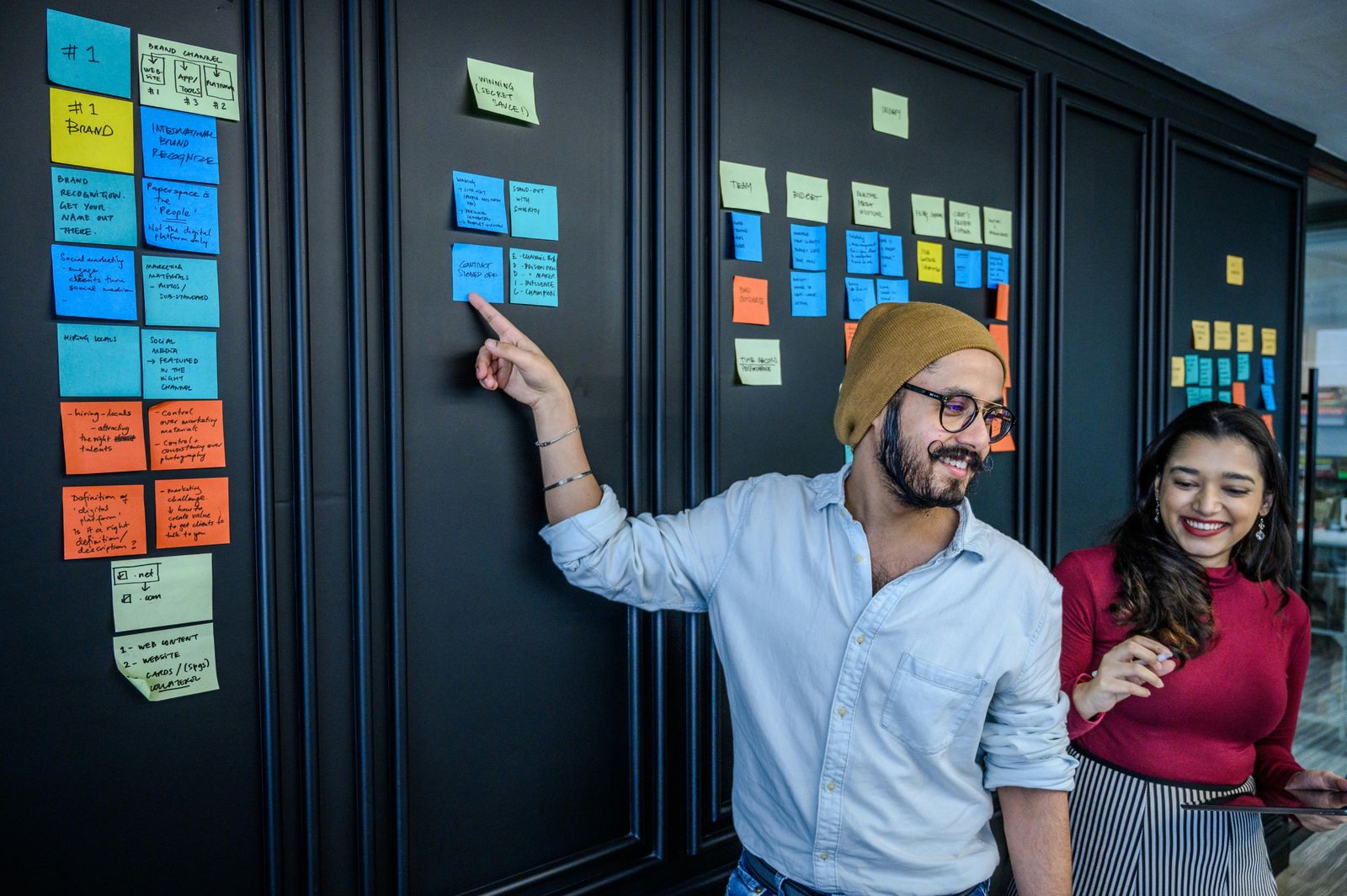 A Man in Brown Beanie Pointing the Sticky Notes