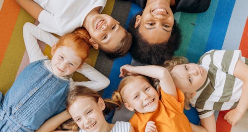 kids lying in a circle on a rug